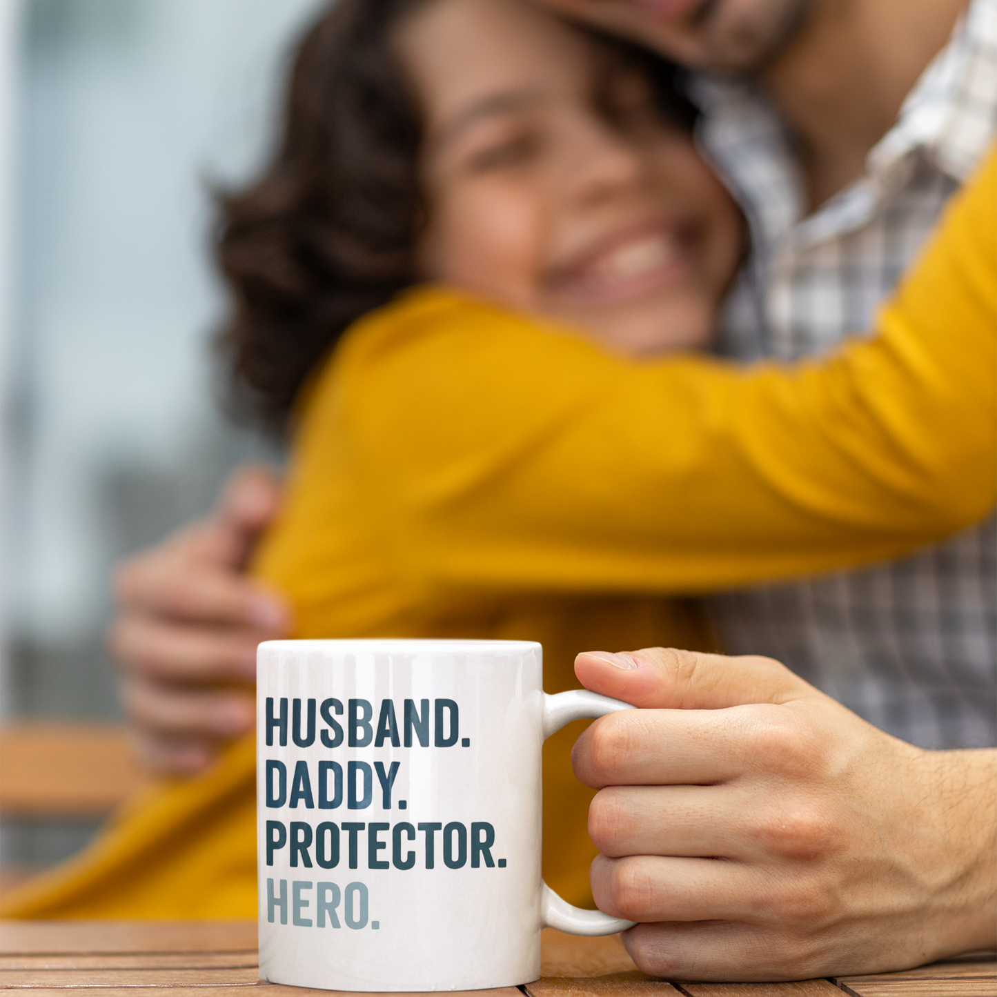 White ceramic mug with bold text reading "HUSBAND. DADDY. PROTECTOR. HERO." in navy and light blue.