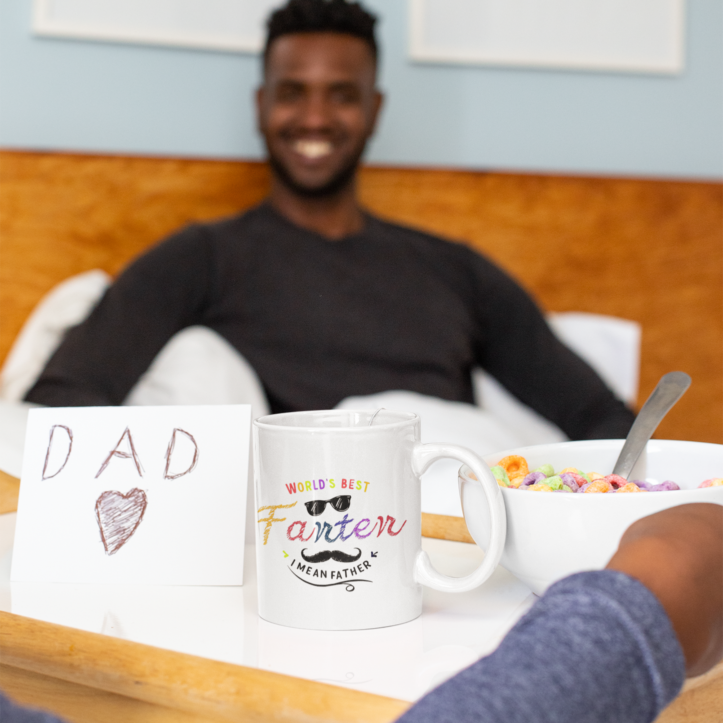 White ceramic mug with colorful text saying “World’s Best Farter I Mean Father,” featuring playful fonts, sunglasses, and a mustache graphic.