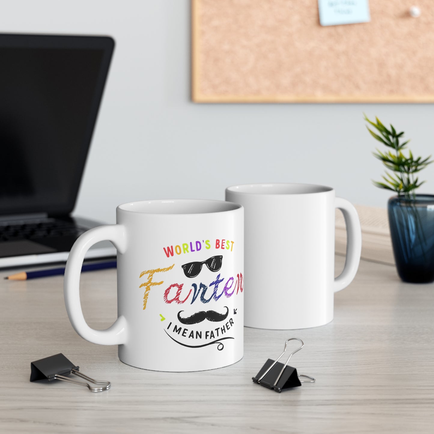 White ceramic mug with colorful text saying “World’s Best Farter I Mean Father,” featuring playful fonts, sunglasses, and a mustache graphic.