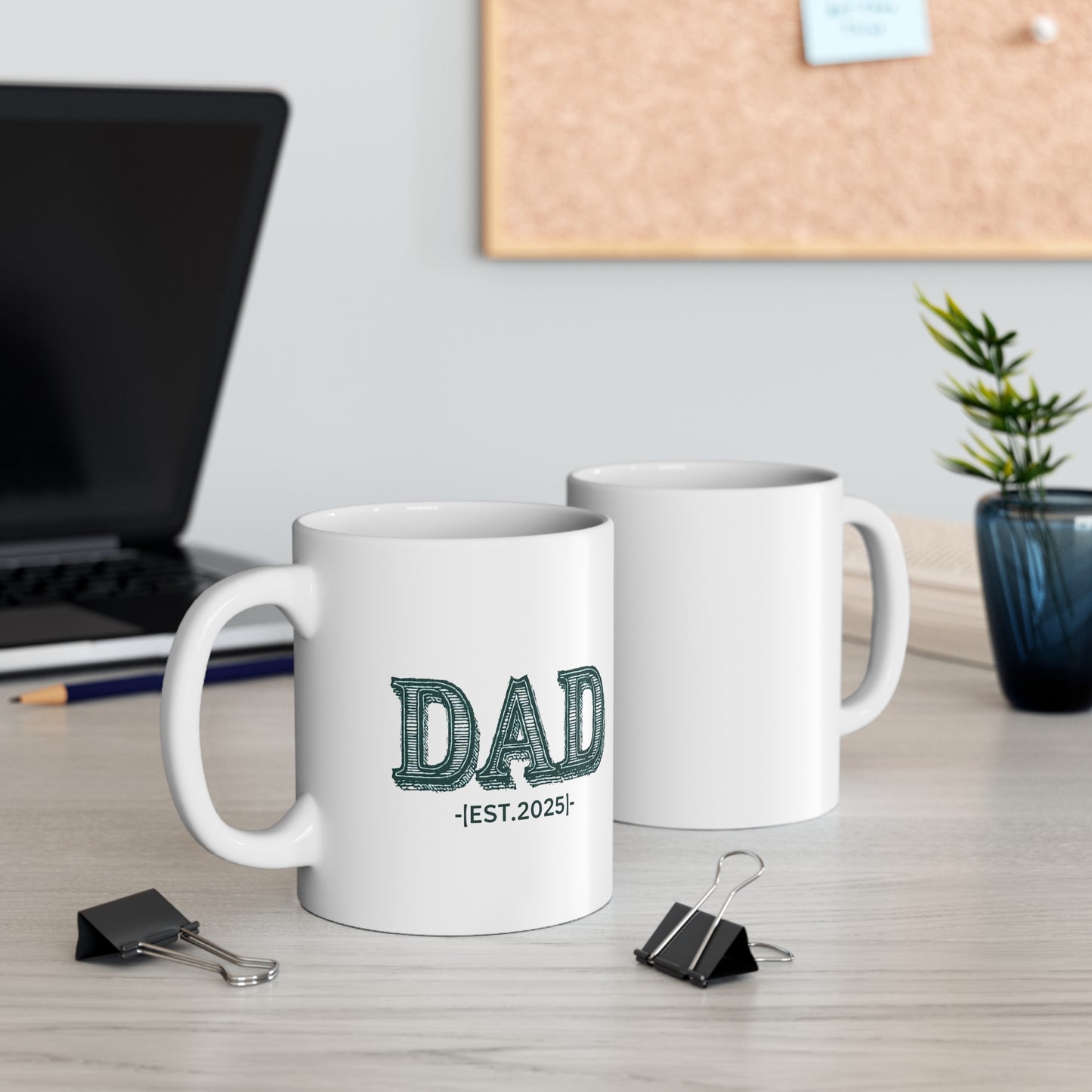 White ceramic coffee mug with bold green vintage-style "DAD" lettering and the text "EST. 2025" below.