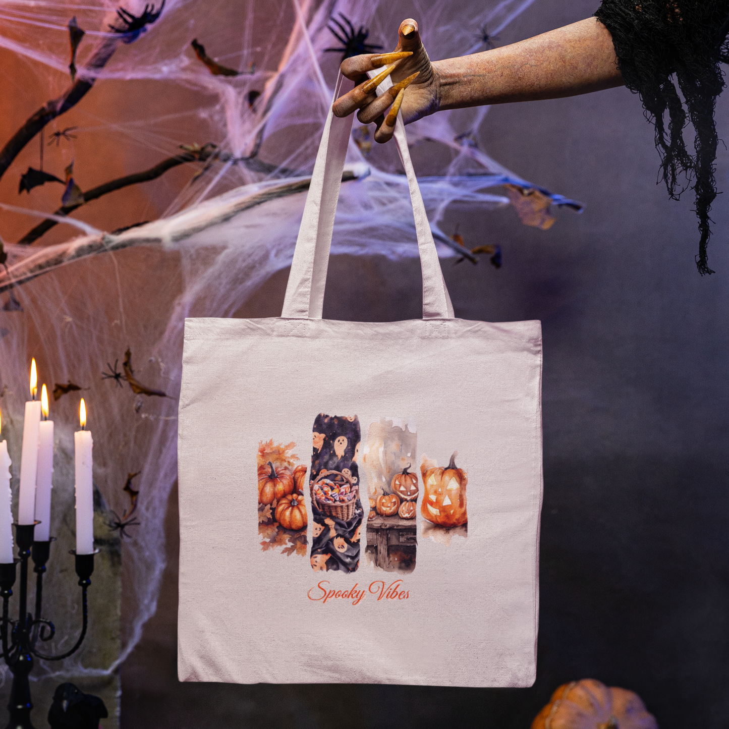 Tote bag with Halloween design held by a gloved hand against a spider web and candle background.