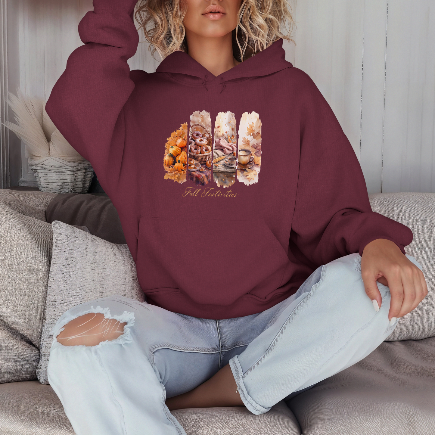 Person wearing a maroon hoodie with a graphic design sitting on a couch.