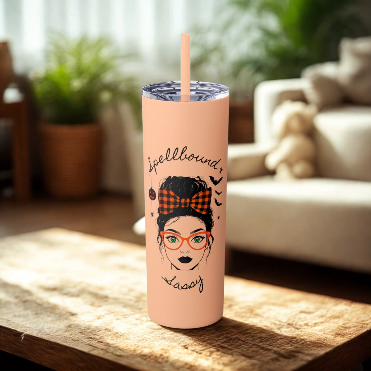 Pink tumbler with a design of a woman's face, text, and a straw on a wooden surface.