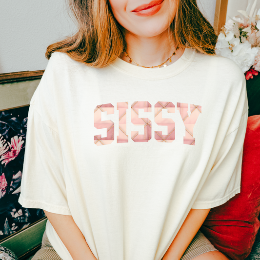 t-shirts with the word “SISSY” in pink geometric print on the front, displayed in black, blue, sage, charcoal, and cream shirt colors