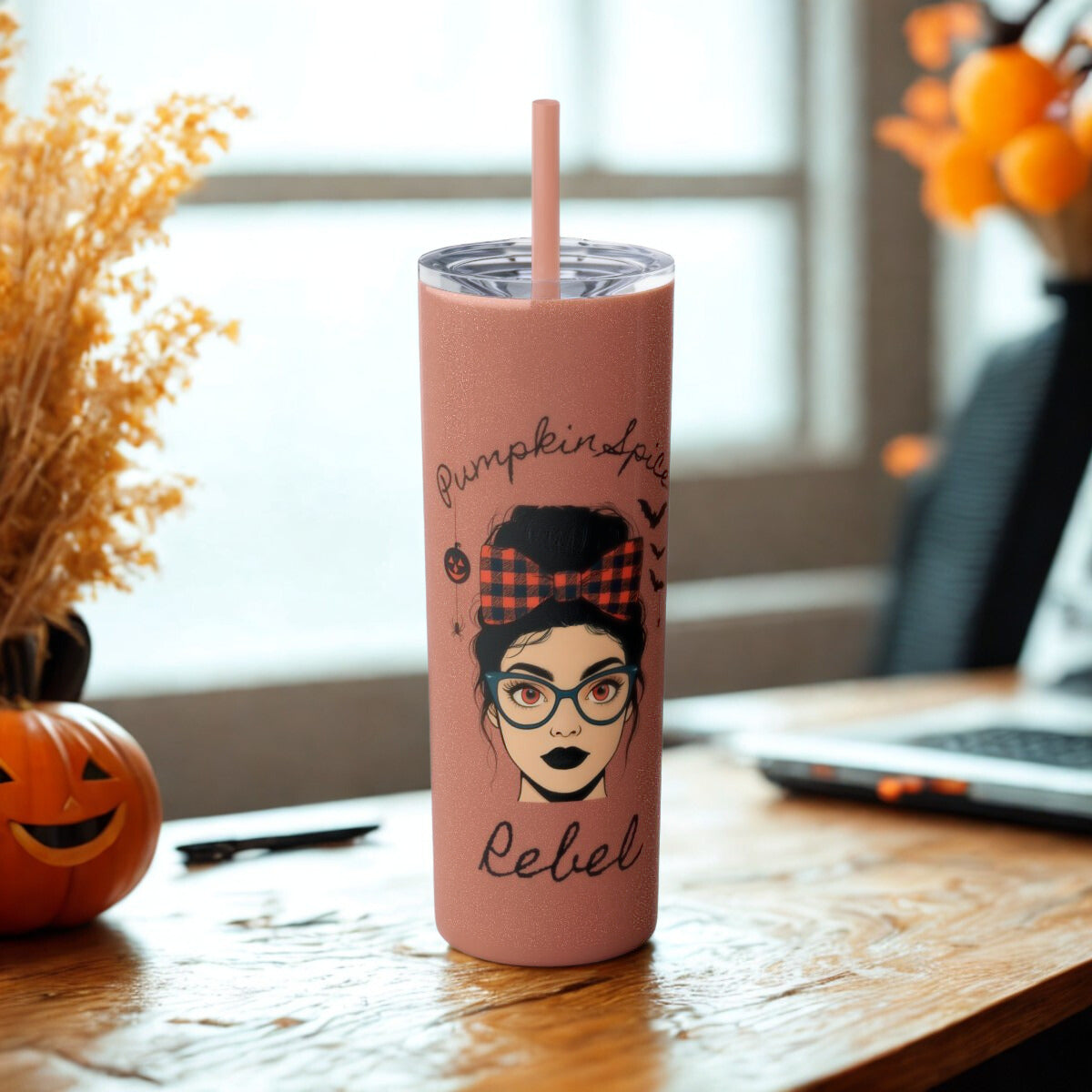 Pink tumbler with a graphic design on a wooden table with a blurred background